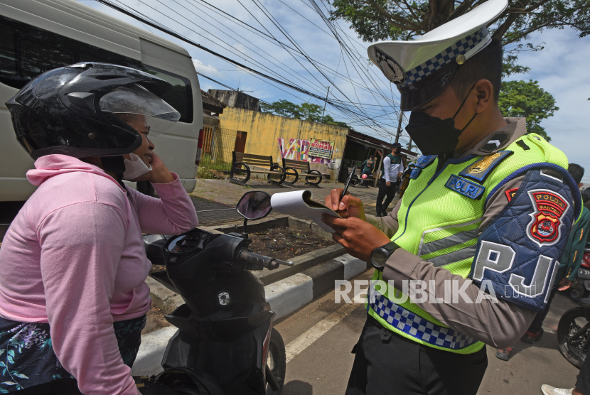 Anggota Polantas menilang warga yang kedapatan menunggak pajak kendaraan bermotor (PKB) saat melakukan razia di Serang, Banten, Jumat (25/11/2022). Razia digelar untuk meningkatkan kesadaran warga membayar PKB sekaligus mendongkrak pendapatan daerah. 