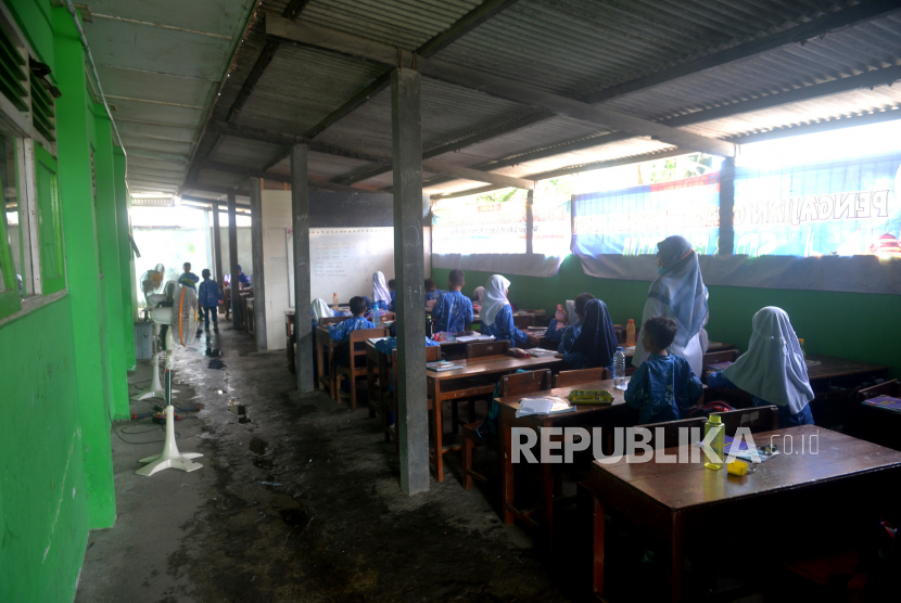 Siswa kelas 1 SD di Bantul mengikuti belajar di parkiran yang menjadi kelas darurat. Kegiatan belajar harus dipindah karena kelas rusak dan berpotensi roboh sewaktu-waktu. (ilustrasi)