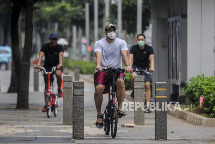 Sejumlah warga bersepeda melintasi trotoar di kawasan Sudirman, Jakarta, Jumat (26/6). Direktorat Lalu Lintas Polda Metro Jaya menerapkan denda tilang bagi pesepeda yang keluar dari jalurnya. Penetapan sanksi ini menyusul berlakunya jalur sepeda sementara atau pop up bike line. Republika/Putra M. Akbar