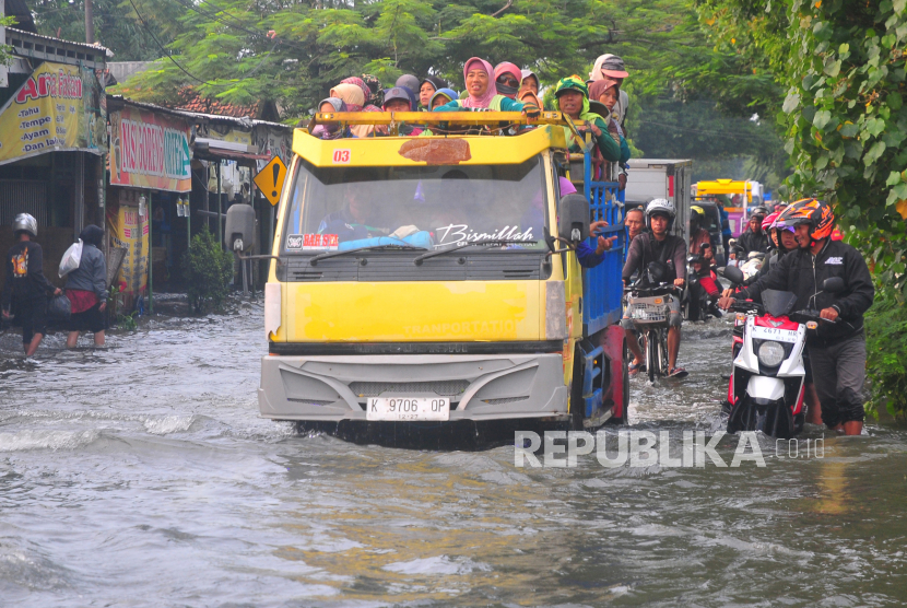 Truk mengangkut warga melintasi banjir di Desa Tanjung Karang, Jati, Kudus, Jawa Tengah, Selasa (19/3/2024).