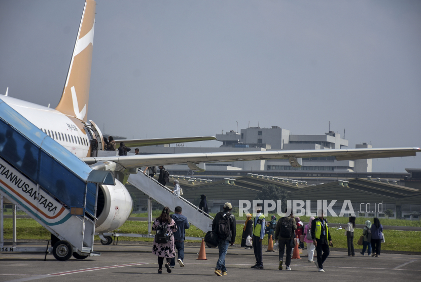 Sejumlah penumpang berjalan menuju pesawat udara maskapai penerbangan Super Air Jet di Bandara Husein Sastranegara, Kota Bandung, Jawa Barat, Jumat (17/3/2023).