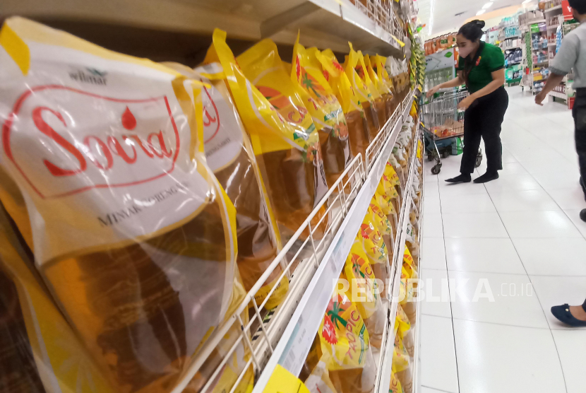 Seorang pekerja menata deretan minyak goreng kemasan 2kg yang dijual di sebuah supermarket di Kota Bandung, Rabu (1/12/2021).  Asosiasi Pengusaha Ritel Indonesia (Aprindo) mengatakan 5,5 juta liter minyak goreng murah sudah tersedia di toko ritel modern