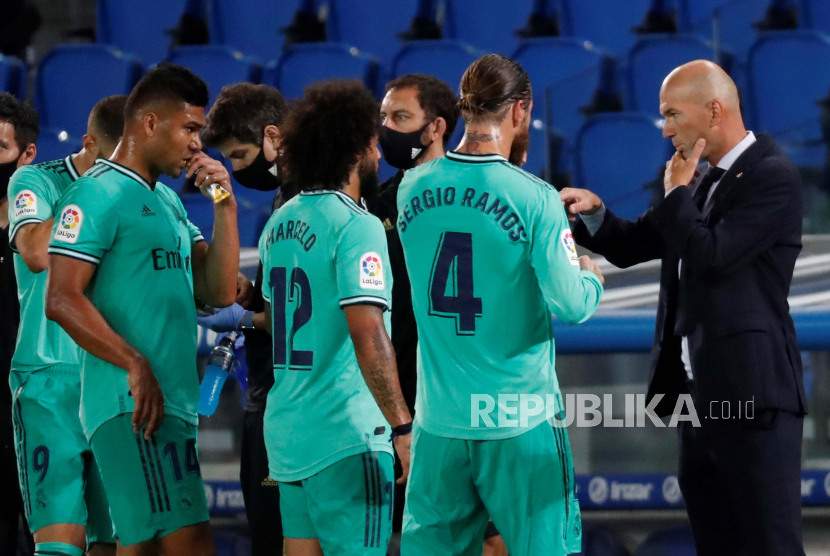 Pelatih Real Madrid Zinedine Zidane (kanan) berbicara dengan para pemainnya pada pertandingan sepak bola LaLiga Spanyol antara Real Sociedad vs Real Madrid di stadion Real Arena di San Sebastian, Basque Country, Spanyol, Ahad (21/6). Pertandingan berakhir dengan kemenangan Real Madrid dengan skor 2-1. EPA-EFE/Juan Herrero