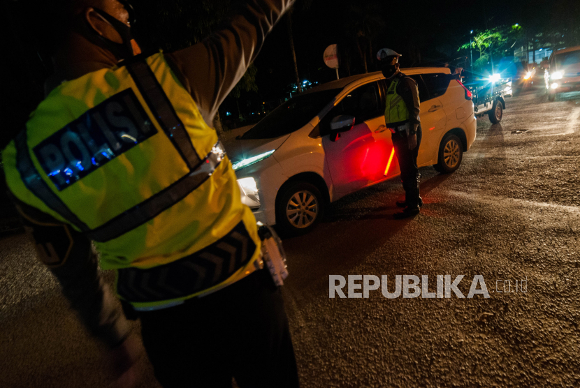 Petugas kepolisian memutarbalikkan kendaraan yang akan melintas di Rangkasbitung, Lebak, Banten, Senin (5/7/2021). Pengetatan mobilitas warga dilakukan dengan menutup sejumlah jalan protokol tersebut sebagai upaya penegakan aturan Pemberlakukan Pembatasan Kegiatan Masyarakat (PPKM) Darurat untuk mengurangi aktivitas warga saat malam hari guna mencegah penyebaran COVID-19. 