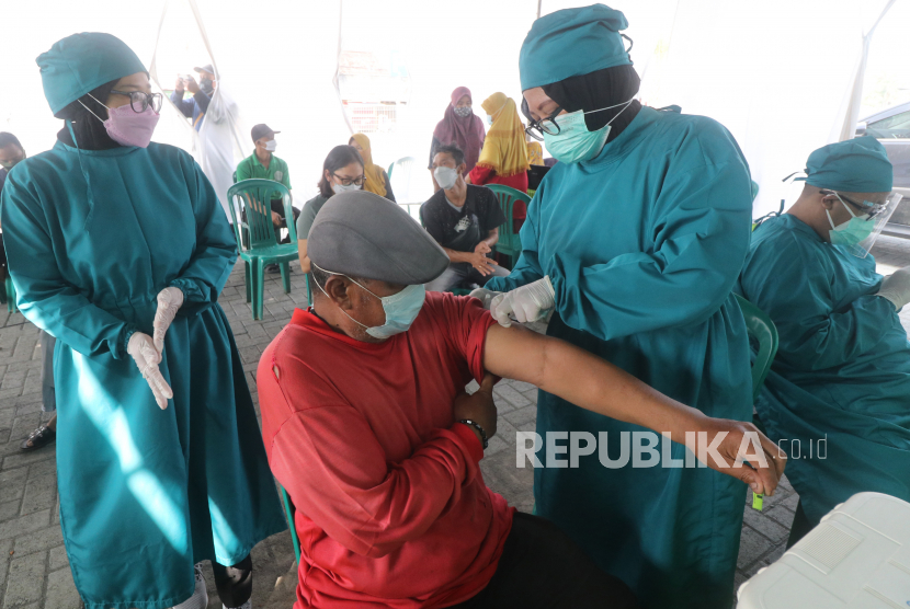 Petugas kesehatan menyuntikkan vaksin COVID-19 AstraZeneca kepada pedagang di pasar tradisional Gringging, Kediri, Jawa Timur, Kamis  (1/4/2021). Pedagang pasar di Kediri mulai mendapatkan suntikan vaksin dosis pertama guna menangkal penyebaran COVID-19 di pasar tradisional yang sering terjadi kerumunan saat bertransaksi.
