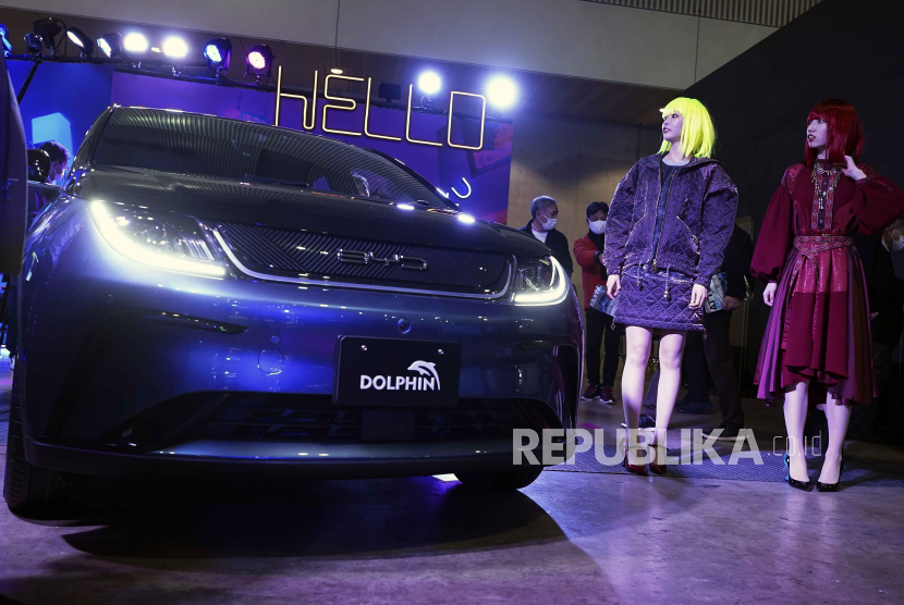 Model berjalan di dekat kendaraan listrik DOLPHIN, salah satu kendaraan terbaru dari produsen mobil China BYD di Tokyo Auto Salon, sebuah acara industri yang mirip dengan pameran otomotif dunia, Jumat, 13 Januari 2023, di Chiba dekat Tokyo.