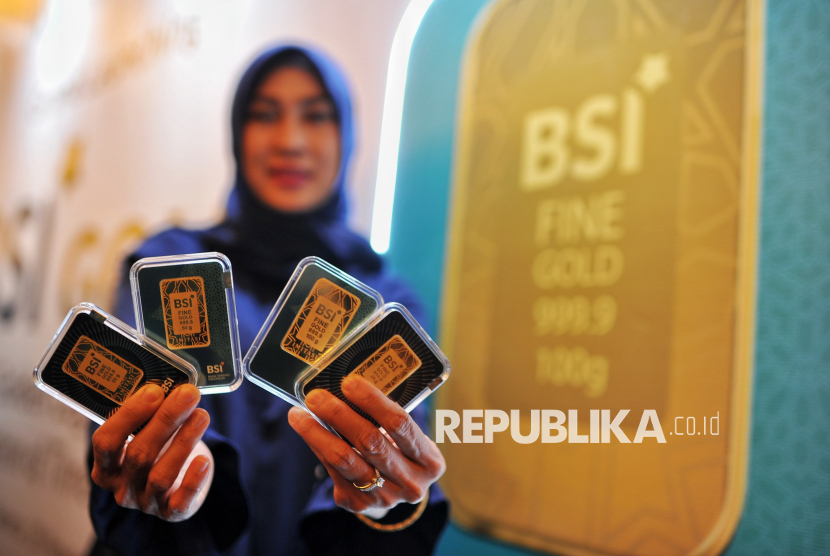 Model menunjukan replika emas batangan BSI saat peluncuran BSI Gold di Jakarta, Kamis (28/11/2024). 