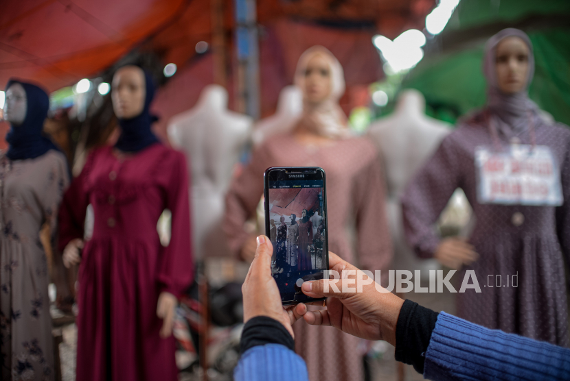Etty Suhayati (50) pedagang di pasar Ramayana Tasik Tanah Abang mengambil gambar untuk dijual secara online di Jakarta, Rabu (18/8). Pada masa pelonggaran PPKM sejumlah pedagang menjual dagangannya secara online untuk mengantisipasi jumlah pengunjung yang sepi. Pedagang mengaku mengalami peningkatan penjualan secara online sebesar 50 persen daripada penjualan secara offline. Republika/Thoudy Badai
