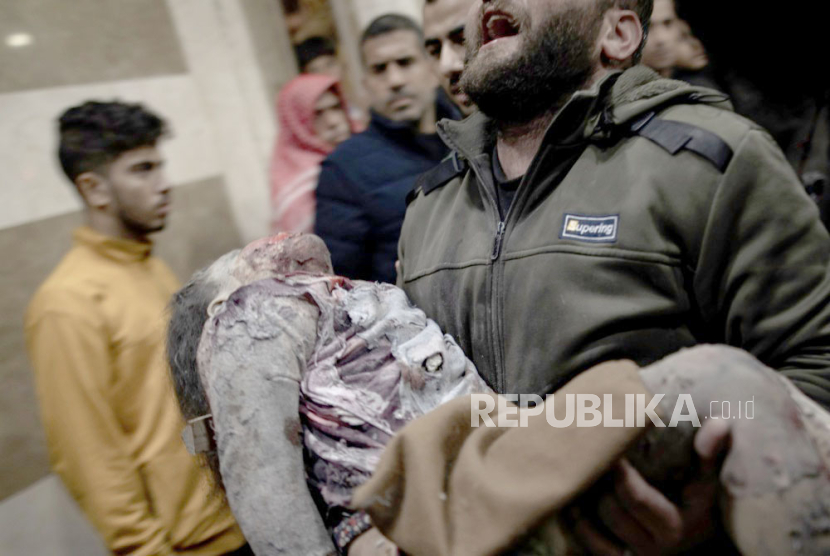 Seorang pria bereaksi saat membawa seorang gadis yang terluka ke Rumah Sakit Nasser di Khan Yunis, Jalur Gaza selatan, 6 Januari 2024