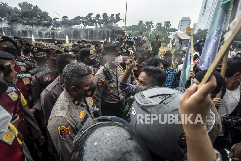 Petugas kepolisian melakukan negosiasi dengan massa aksi yang akan melakukan unjuk rasa di depan patung kuda, Jakarta, Senin (11/4/2022).  