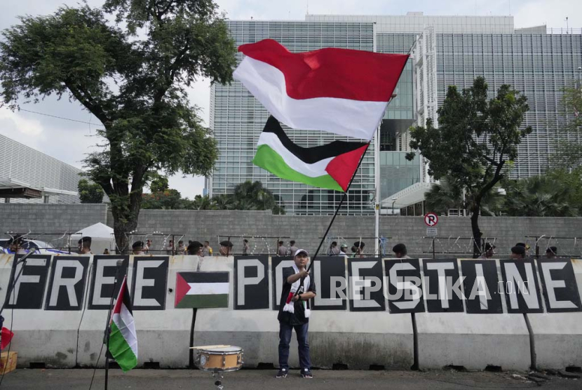 Para pengunjuk rasa mengibarkan bendera Palestina dan Indonesia saat unjuk rasa mendukung Palestina di luar Kedutaan Besar AS di Jakarta, Indonesia, Jumat, (19/4/2024).