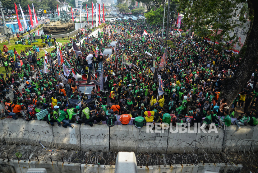 Sejumlah pengemudi ojek online (ojol) melakukan aksi unjuk rasa kawasan Patung Kuda, Jakarta, Kamis (29/8/2024). Mereka menuntut pemerintah dan perusahaan transportasi online untuk melegalkan status profesi driver ojol dalam undang-undang (UU). Selain itu, mereka juga menuntut perusahaan aplikasi untuk menurunkan biaya potongan aplikasi. Mereka datang dengan menggunakan atribut perusahaan masing-masing seperti Gojek, Grab, Shopee, dan Maxim.