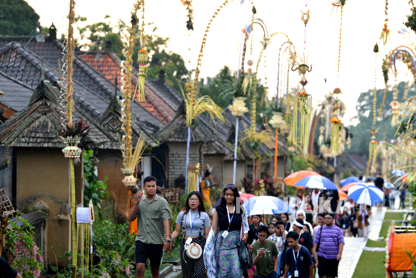 Wisatawan domestik berjalan di sekitar deretan rumah tradisional di Desa Wisata Penglipuran, Bangli, Bali (ilustrasi) 