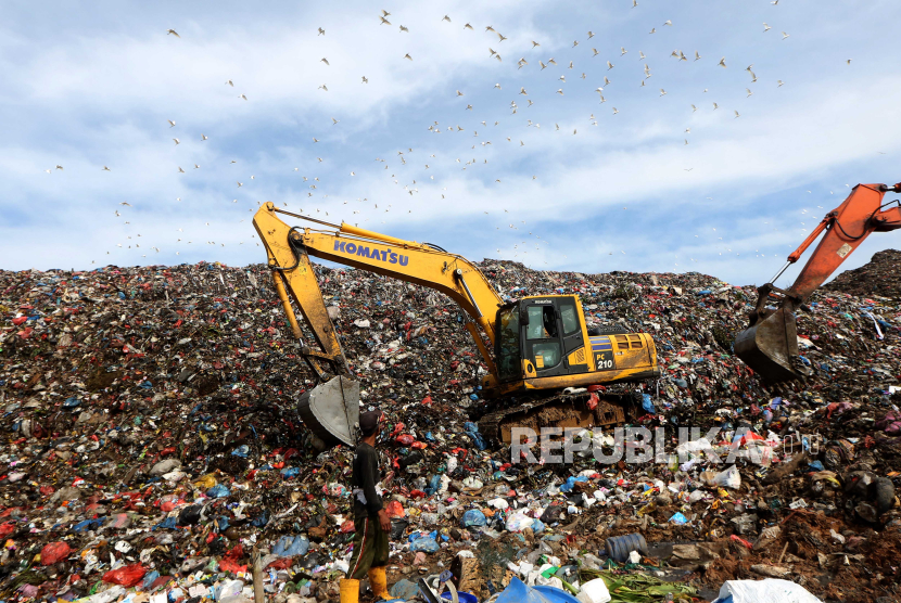 Pekerja menggunakan alat berat saat menangani sampah di Tempat Pembuangan Akhir (TPA) (ilustrasi)