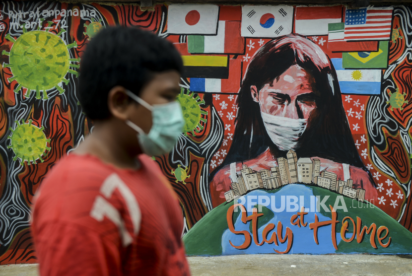 Seorang anak melintas di dekat tembok yang dihiasi mural saat pemberlakuan Pembatasan Sosial Berskala Besar (PSBB) di Depok, Jawa Barat, (ilustrasi).