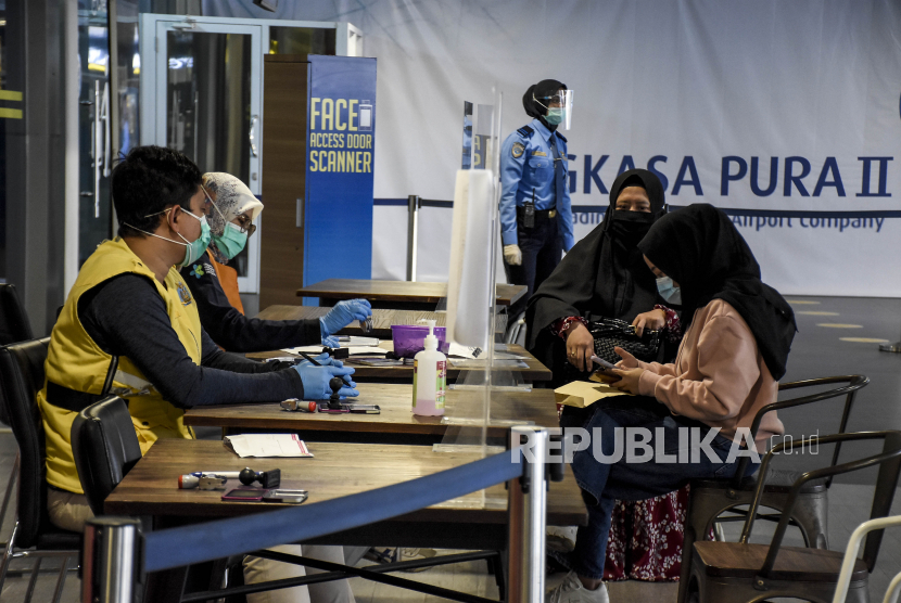 Sejumlah calon penumpang melakukan verifikasi pemeriksaan kesehatan di Bandara Husein Sastranegara, Kota Bandung, Ahad (13/12). PT Angkasa Pura II menyiapkan beberapa hal untuk memastikan penerbangan berjalan lancar di seluruh bandara perseroan jelang libur Natal dan Tahun Baru (Nataru) 2021 diantaranya, menyiapkan ketersediaan jadwal penerbangan tambahan, memperpanjang operasional bandara dan memastikan kesiapan dan kesigapan sumber daya manusia serta prosedur protokol kesehatan. Foto: Abdan Syakura/Republika