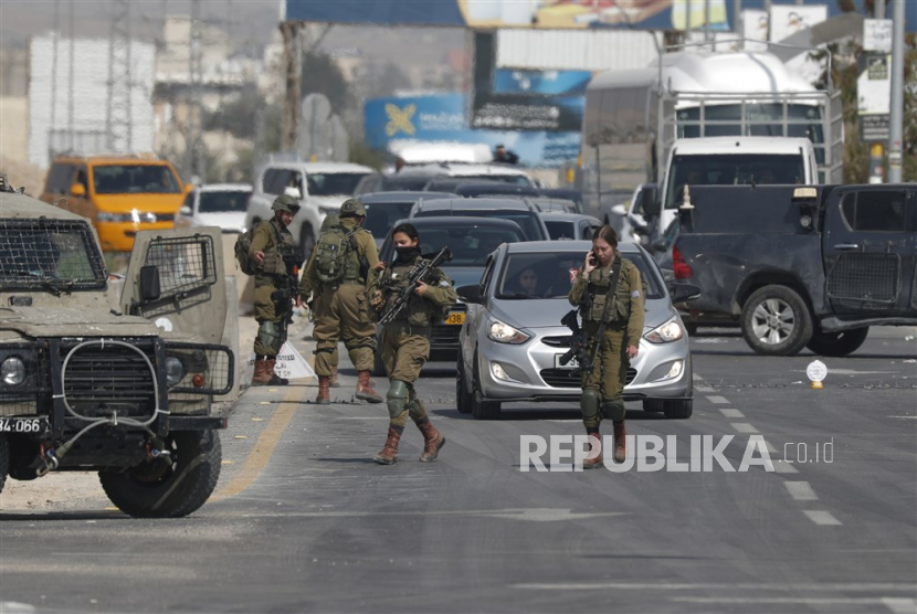 File foto tentara Israel memeriksa mobil Palestina di sebuah pos pemeriksaan di pintu masuk kota Jericho di Tepi Barat, 28 Februari 2023. 