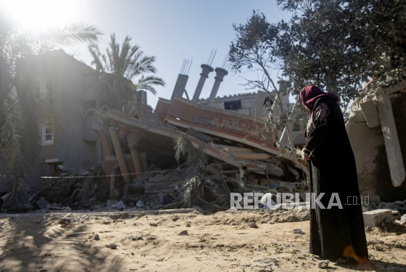 Seorang wanita Palestina berdiri di dekat reruntuhan rumah mereka setelah serangan udara Israel, di kamp pengungsi Khan Yunis, Jalur Gaza selatan, 5 Maret 2024. 