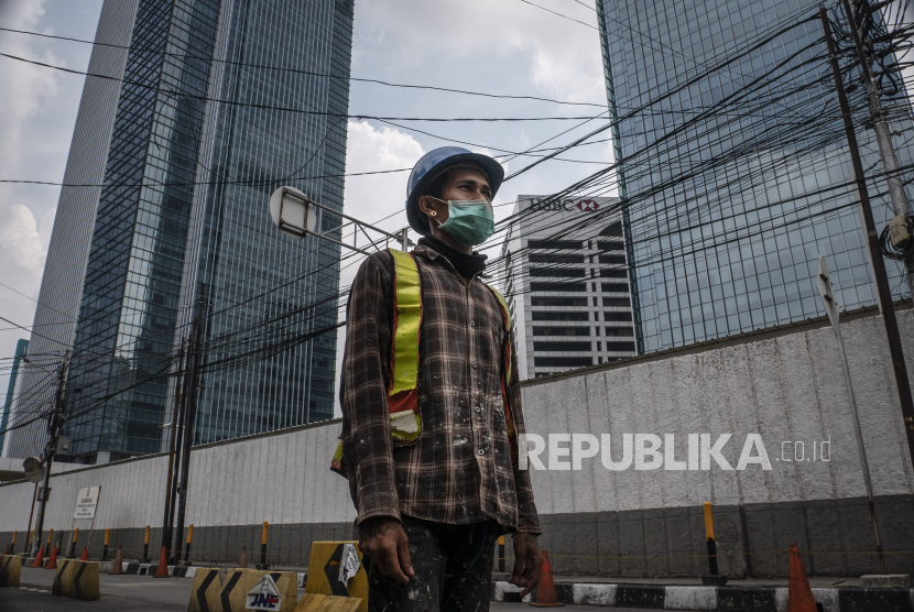 Pekerja berjalan dengan latar belakang gedung perkantoran di kawasan Kuningan, Jakarta. Jumlah penerima bantuan subsidi gaji akan ditambah menjadi 15,7 juta orang. Subdisi gaji diberikan ke mereka dengan pendapatan total kurang dari Rp 5 juta.