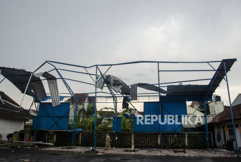 Warga membereskan atap baja ringan yang roboh setelah diterjang angin puting beliung di Desa Dewasari, Kabupaten Ciamis, Jawa Barat, Selasa (29/3/2022). Dampak angin puting beliung yang menerjang daerah tersebut mengakibatkan puluhan rumah rusak dan pohon tumbang. 