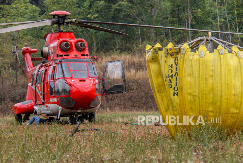 Petugas memeriksa helikopter Super Puma BNPB di kawasan Gunung Arjuno, Pasuruan, Jawa Timur, Jumat (8/9/2023). BNPB menambah satu unit helikopter (total dua) tersebut sebagai upaya pemerintah untuk memadamkan sisa api yang membakar seluas 4.796 hektar per Rabu (8/9) hutan dan lahan (karhutla) Gunung Arjuno agar lebih efektif. 