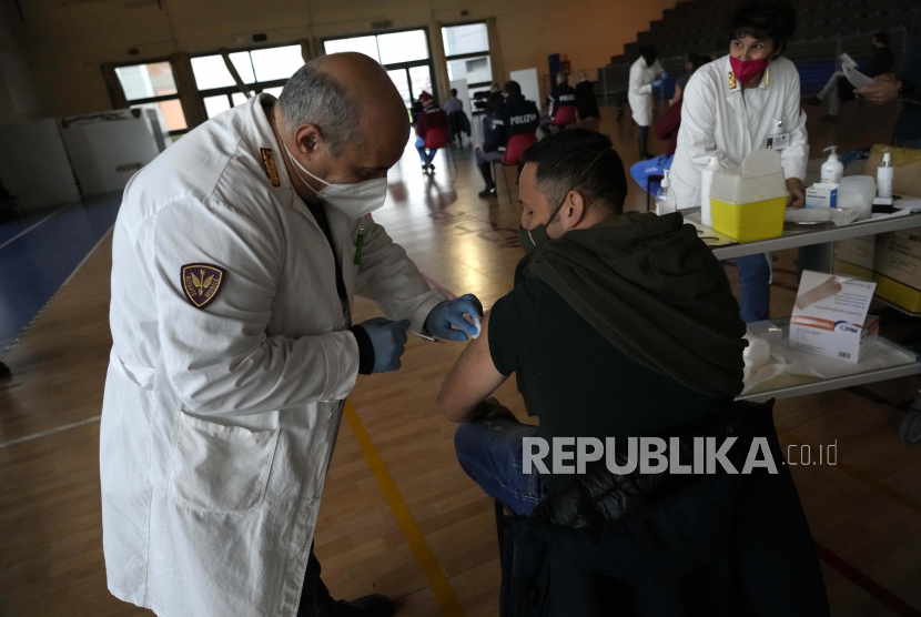 Petugas polisi Italia menerima vaksinasi mereka terhadap COVID-19 di pusat vaksinasi yang didirikan di gym barak polisi di Roma, Jumat, 10 Desember 2021. Pemerintah Italia mewajibkan vaksinasi COVID-19 kepada polisi mulai 15 Desember.