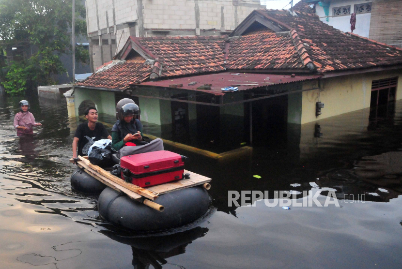 Warga melintasi jalan yang tergenang banjir dengan perahu rakit di Dukuh Tanggulangin, Jati Wetan, Kudus, Sabtu (16/3/2024). Menurut data BPBD setempat, bencana banjir sejak Kamis (14/3) akibat intensitas hujan yang tinggi serta meluapnya sungai Wulan tersebut meluas dan merendam 10.430 rumah di 29 desa dari lima kecamatan dan sebanyak 32.952 jiwa terdampak serta 911 jiwa mengungsi. 