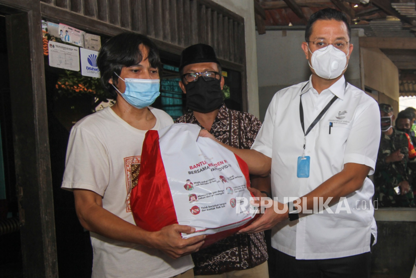 Menteri Sosial Juliari P Batubara (kanan) memberikan paket bantuan kepada warga terdampak COVID-19 di Beji, Depok, Jawa Barat, Kamis (14/5/2020). Sebanyak 123