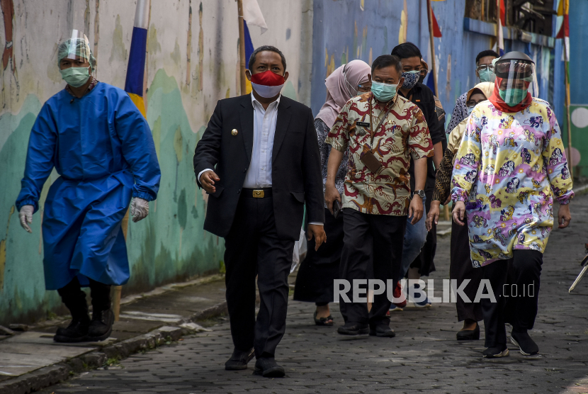 Wakil Wali Kota Bandung Yana Mulyana (kedua kiri) berjalan keluar usai meninjau penyuntikan vaksin Covid-19 di Puskesmas Garuda, Jalan Dadali, Kota Bandung, Jumat (14/8). Sedikitnya 100 relawan disuntik vaksin Covid-19 setelah menjalani pemeriksaan kesehatan dan tes usap yang digelar di lima lokasi yakni Balai Kesehatan Unpad, Puskesmas Garuda, Puskesmas Dago, Puskesmas Ciumbuleuit, Puskesmas Sukapakir. Foto: Abdan Syakura/Republika