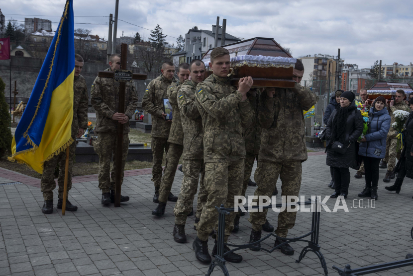 Tentara membawa peti mati tentara Simakov Oleksandr berusia 41 tahun, selama upacara pemakamannya, setelah dia terbunuh dalam aksi, di pemakaman Lychakiv, di Lviv, Ukraina barat, Senin, 4 April 2022