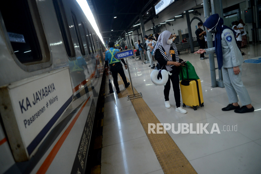 Penumpang berjalan menuju rangkaian kereta di Stasiun Pasar Senen, Jakarta Pusat, Ahad (16/4/2023). 