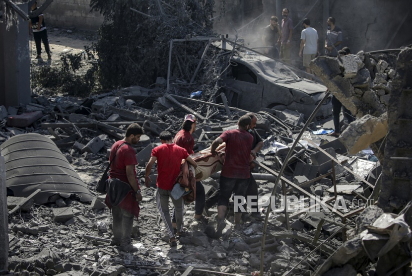 Warga Palestina mencari jenazah dan korban di antara puing-puing rumah keluarga Al Shawa yang hancur akibat serangan udara Israel di Gaza, Palestina, Rabu (25/10/2023). 