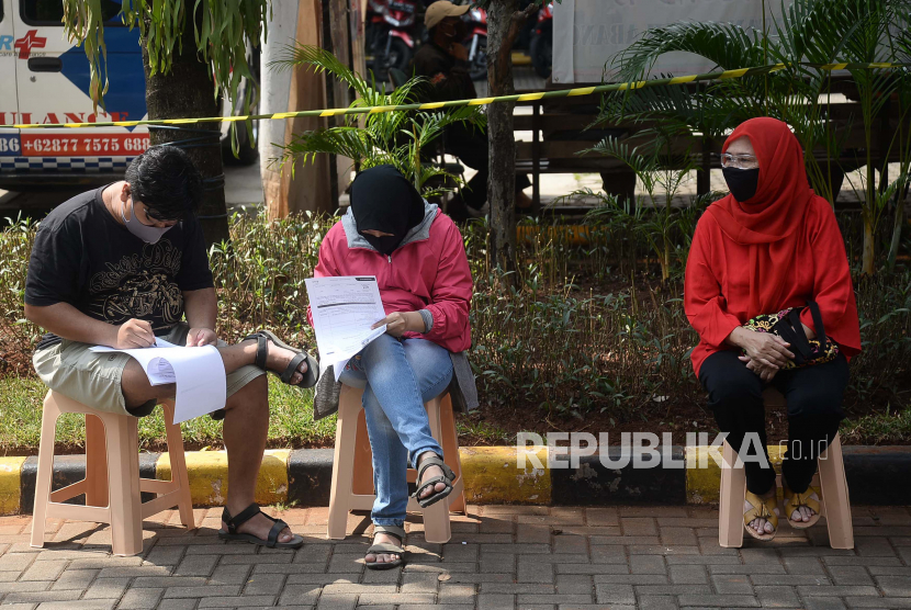 Warga duduk sambil formulir pendaftaran swab test Covid-19 gratis di Kantor Kecamatan Tanah Abang, Jakarta, Ahad (21/6/2022). Kebiasaan duduk sambil menyilangkan kaki dapat memicu masalah kesehatan. 