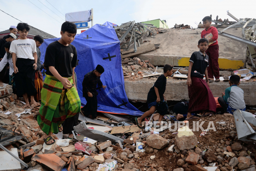 Warga berjalan di dekat mini market yang roboh di Kampung Kadudampit, Rancagoong, Cianjur, Jawa Barat, Selasa (22/11/2022). BPBD Provinsi Jawa Barat menyiapkan dapur umur untuk korban gempa Cianjur.