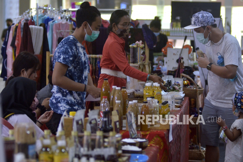 Pedagang dan pembeli melakukan transaksi saat kegiatan Bali Kui 2.0 Fair UMKM Bali Naik Kelas di sebuah pusat perbelanjaan di kawasan Kuta, Badung, Bali, Kamis (29/10/2020). Kegiatan tersebut diselenggarakan Perusahaan Daerah (Perusda) Provinsi Bali untuk mendorong produk Usaha Mikro Kecil dan Menengah (UMKM) pangan dan sandang lokal Bali agar dapat dipasarkan ke pasar retail modern. 