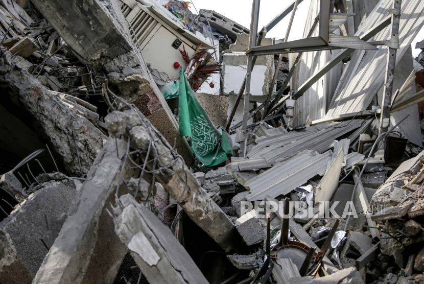 Bendera Hamas terlihat di tengah reruntuhan masjid yang hancur setelah serangan udara Israel di Kota Gaza, 09 Oktober 2023.