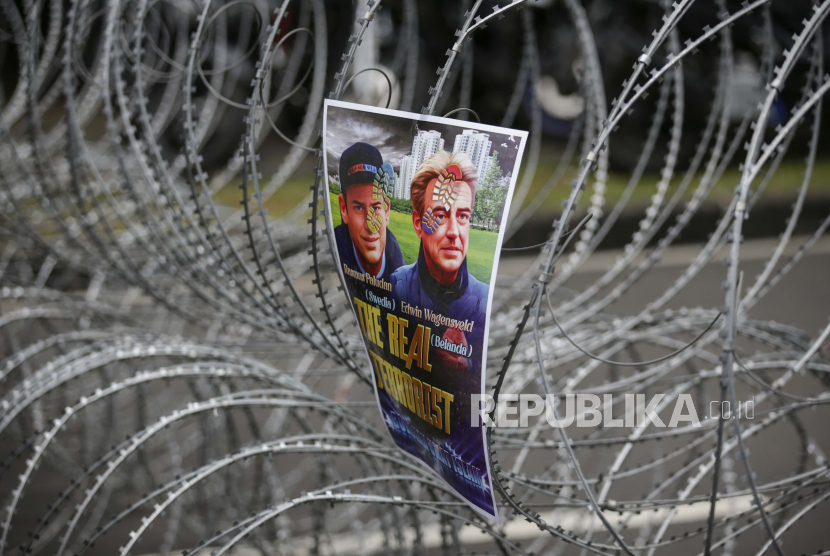 Sebuah poster dengan gambar Rasmus Paludan dan Edwin Wagensveld digantung di kawat berduri selama unjuk rasa anti-Swedia di luar kedutaan Swedia di Jakarta.