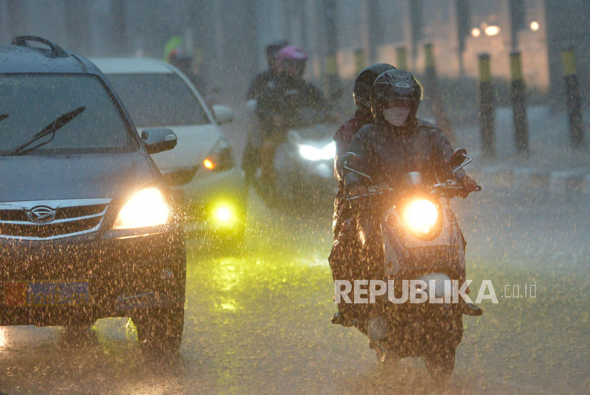Pengendara motor mengenakan jas hujan saat berkendaraan melintasi guyuran hujan di Jakarta. Ada jurus sendiri agar tetap aman berkendara saat musim hujan.