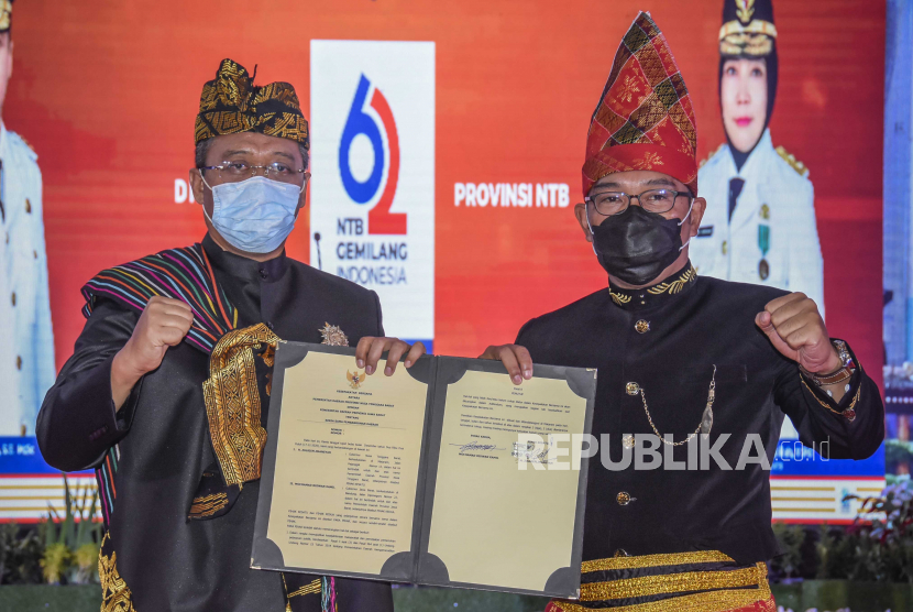 Gubernur NTB Zulkieflimansyah (kiri) bersama Gubernur Jawa Barat Ridwan Kamil (kanan) menunjukkan surat nota kesepahaman (MoU) kerjasama Jabar - NTB.