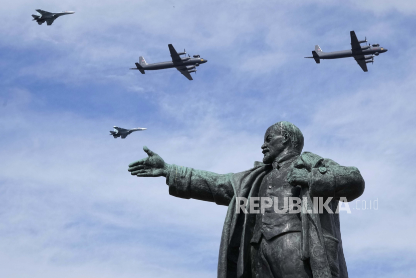 Pesawat militer terbang di atas patung pendiri Uni Soviet Vladimir Lenin saat latihan parade Angkatan Laut di St.Petersburg, Rusia, Kamis, 28 Juli 2022. Patung Lenin juga akan dipasang di Melitopol, kota yang direbut Rusia tak lama setelah mereka melancarkan agresi ke Ukraina pada 24 Februari lalu.