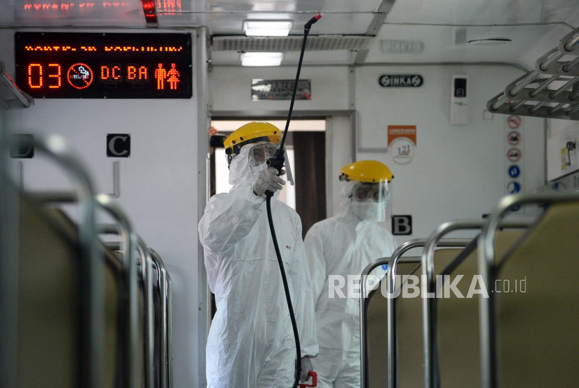 32 Perjalanan KA Lintas Selatan Jawa Disetop. Petugas menyemprotkan cairan disinfektan di bagian dalam gerbong kereta di Stasiun Senen, Jakarta.