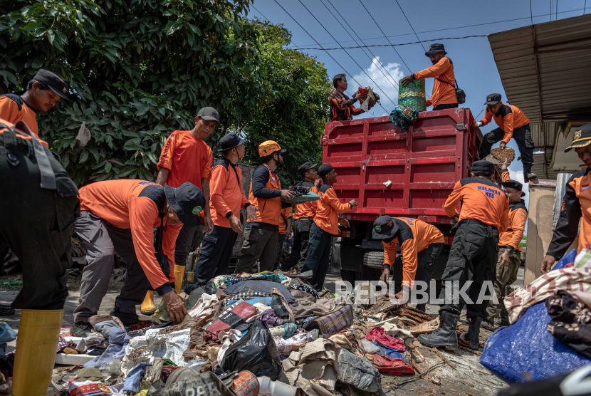 Relawan membersihkan jalan desa dari sampah serta barang warga yang hanyut karena banjir di Desa Karanganyar, Kabupaten Demak, Jawa Tengah, Selasa (20/2/2024). 