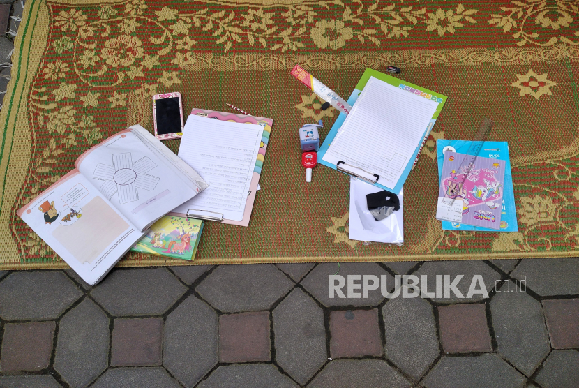 Peralatan belajar anak-anak siswa SD belajar bersama jalan kampung di Bintaran Kidul, Yogyakarta, Rabu (29/7). Layanan Internet Masyarakat (LIMas) memberikan kases internet gratis untuk anak-anak untuk mempermudah kegiatan belajar secara daring.
