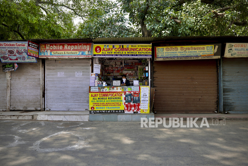 Seorang penjaga toko aksesori ponsel menunggu pelanggan ketika masa lockdown diperpanjang di New Delhi, India, Senin (18/5). India telah mencatat rekor lonjakan harian dalam kasus baru virus Corona