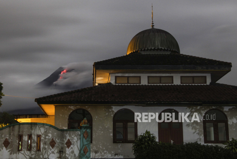 [Ilustrasi] Lava panas mengalir turun dari kawah Gunung Merapi, sebagian terlihat di belakang sebuah masjid di Sleman.