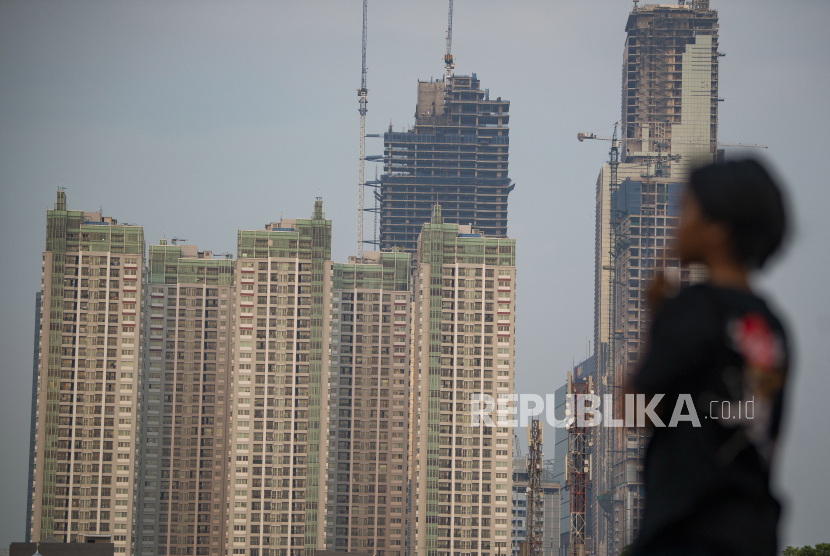 Seorang warga berdiri dengan latar belakang gedung-gedung bertingkat di Jakarta, Senin (30/8). Pemerintah menyebut sejumlah negara sudah mengalami pertumbuhan yang positif pada tahun ini.