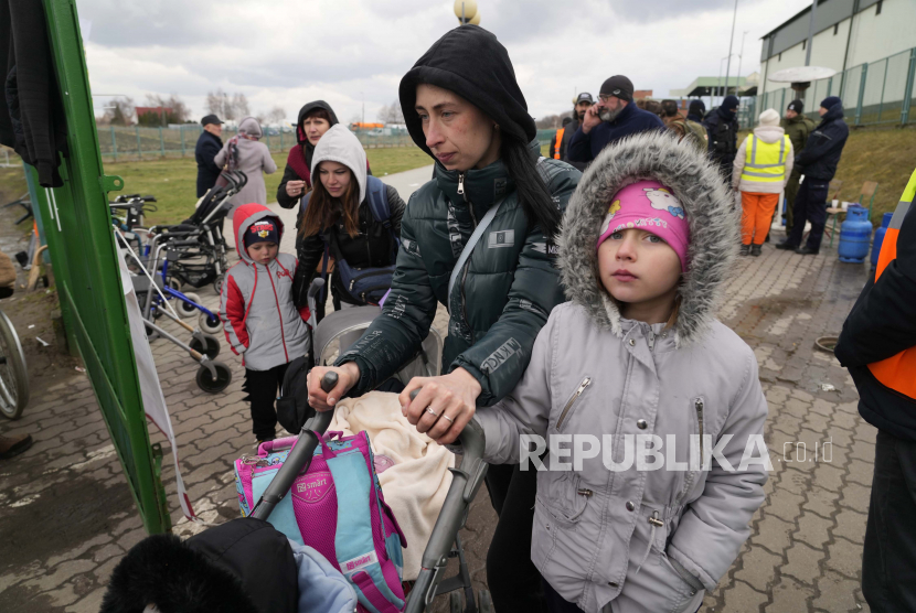 Pengungsi berjalan setelah melarikan diri dari perang dari negara tetangga Ukraina di perbatasan di Medyka, Polandia tenggara, Minggu, 3 April 2022. Uni Emirat Arab (UEA) mengirim 27 ton bantuan pangan dan pasokan medis untuk pengungsi Ukraina di Polandia.