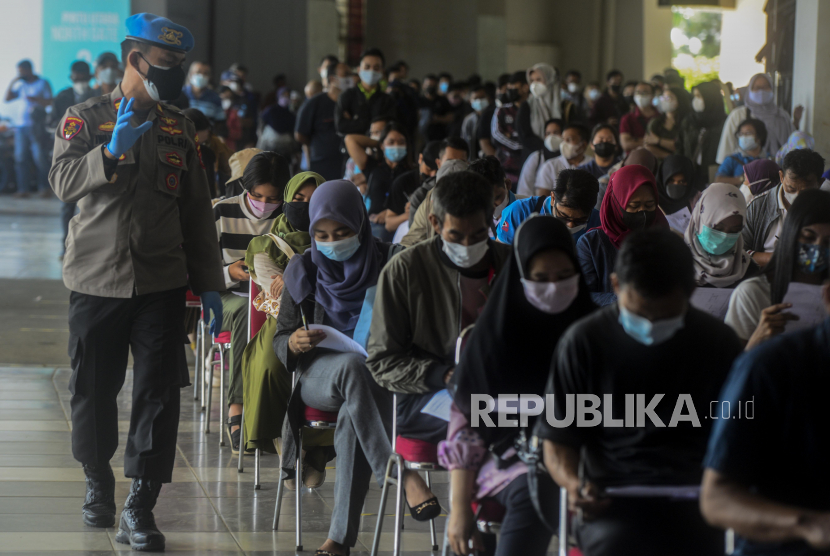 Polisi mengatur barisan warga yang akan disuntik vaksin Covid-19 saat vaksinasi massal di Stadion Pakansari, Cibinong, Kabupaten Bogor, Jawa Barat, Sabtu (26/6). Vaksinasi massal yang diselenggarakan oleh Polri secara serentak di 34 Polda itu dilakukan kepada 1.031.056 masyarakat di Indonesia dalam rangka memperingati HUT Bhayangkara ke-75. Republika/Putra M. Akbar
