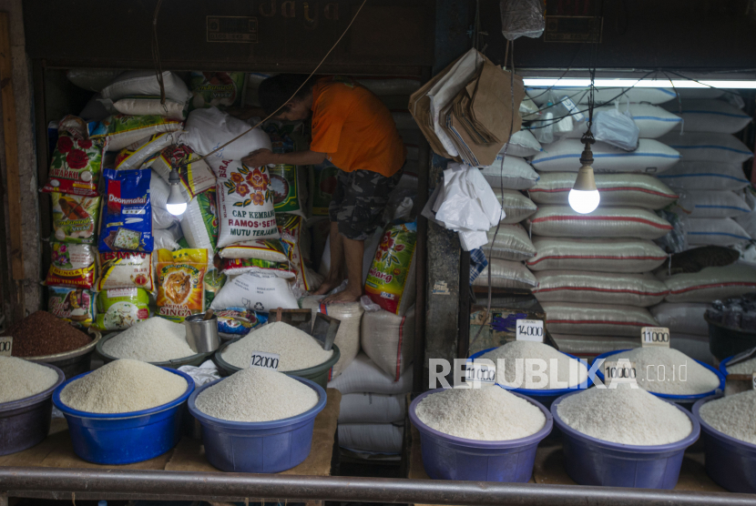 Pedagang menata karung-karung berisi beras yang dijual di pasar. 