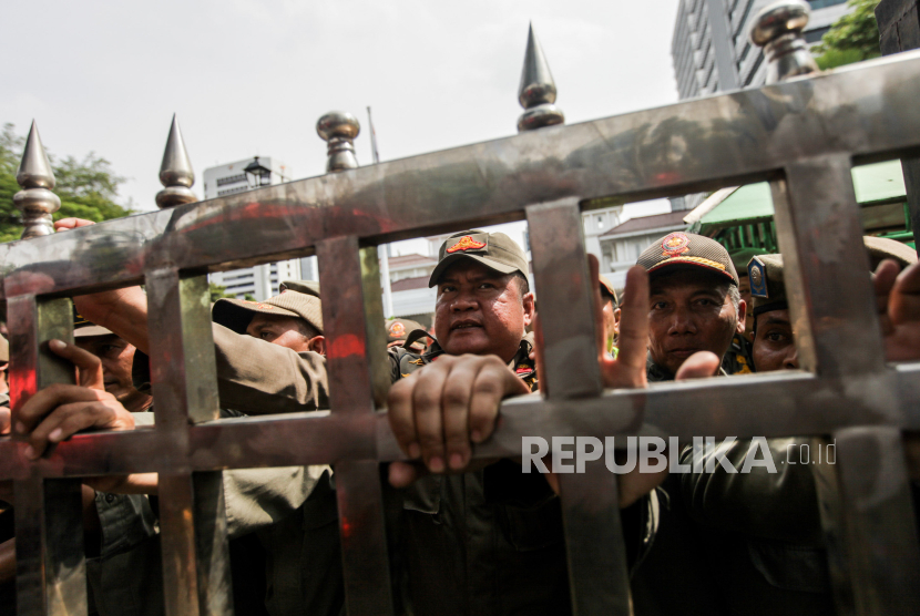 Satpol PP menahan pagar yang didorong buruh saat aksi (ilustrasi) . 